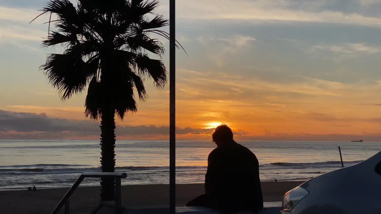 Silhouette Man Sitting On A Bench At Sunset Then Walks Away In Slow Motion