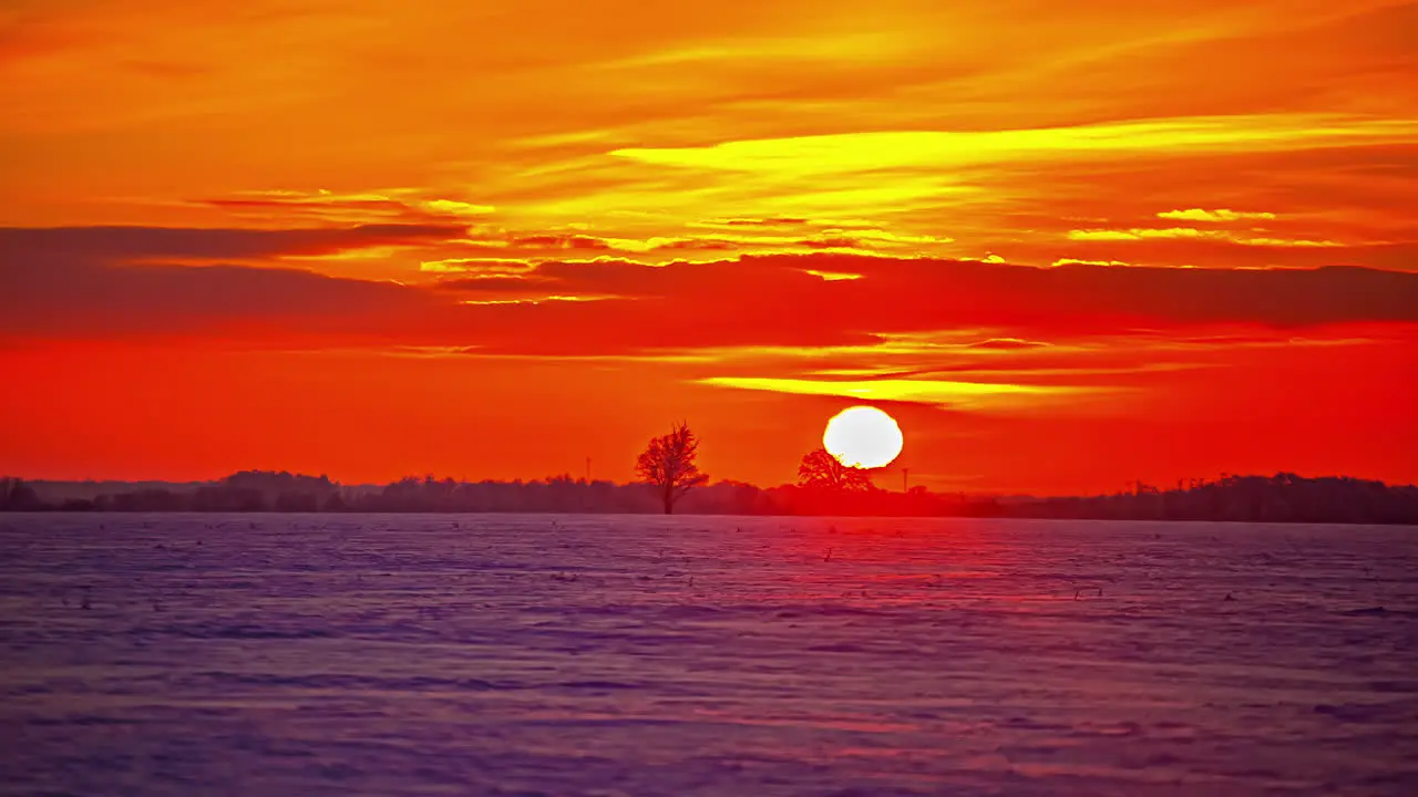 Glowing bright sunset time lapse with the sun descending beyond the horizon