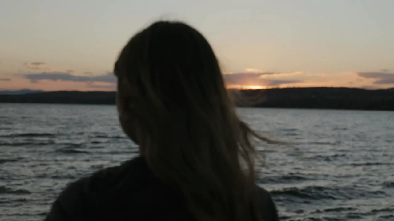 Rear View Of Young Tourist Woman Relaxing By The Beach At Sunset