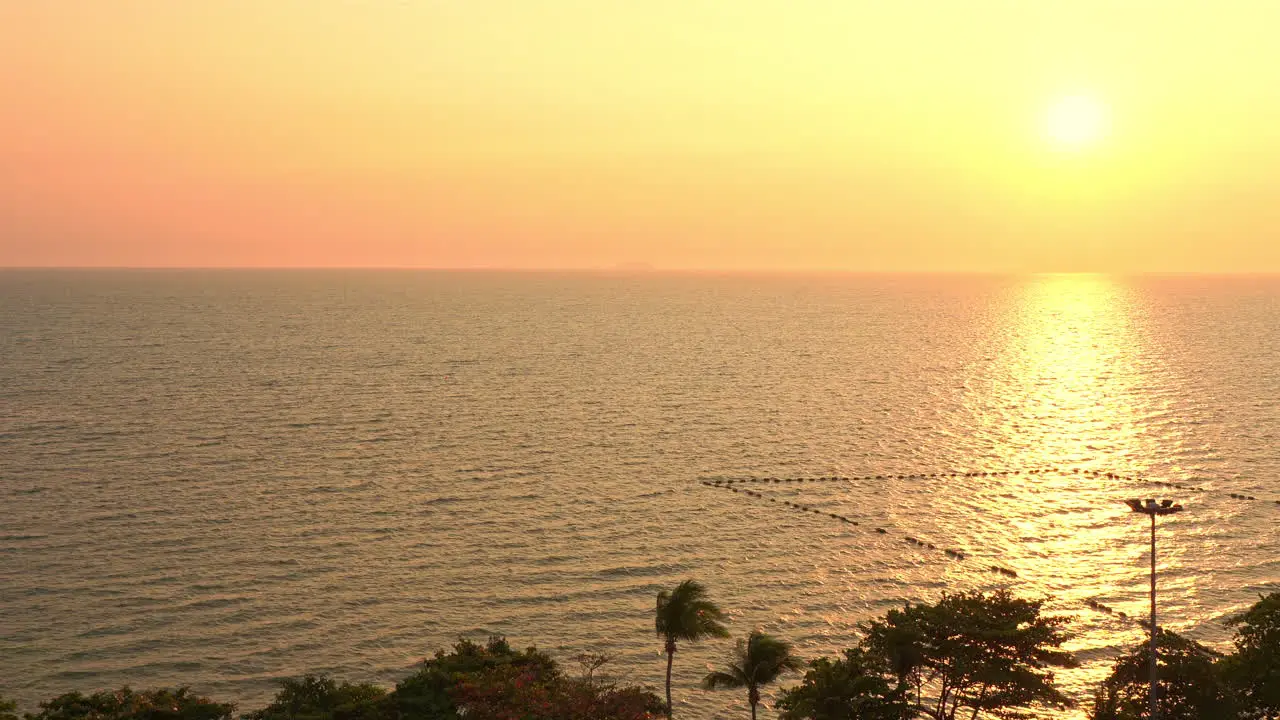 A golden sunset reflects in the Ocean along a tropical paradise