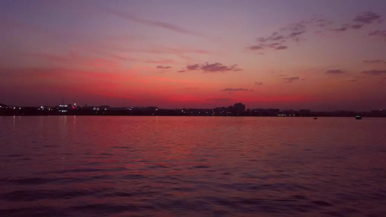 A Colorful Scene of Lake and City During Sunset