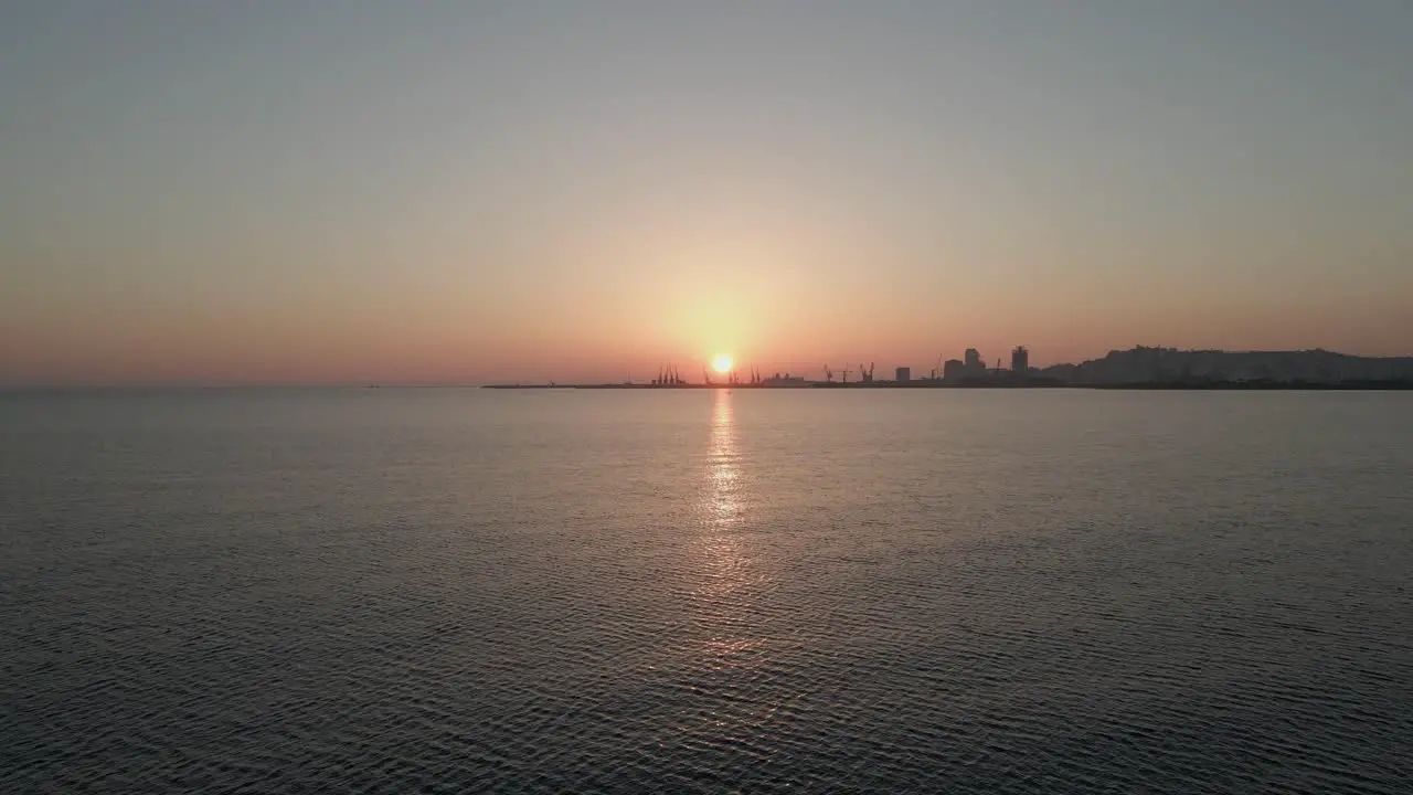 Durres Container Port on horizon of calm golden Adriatic Sea sunset