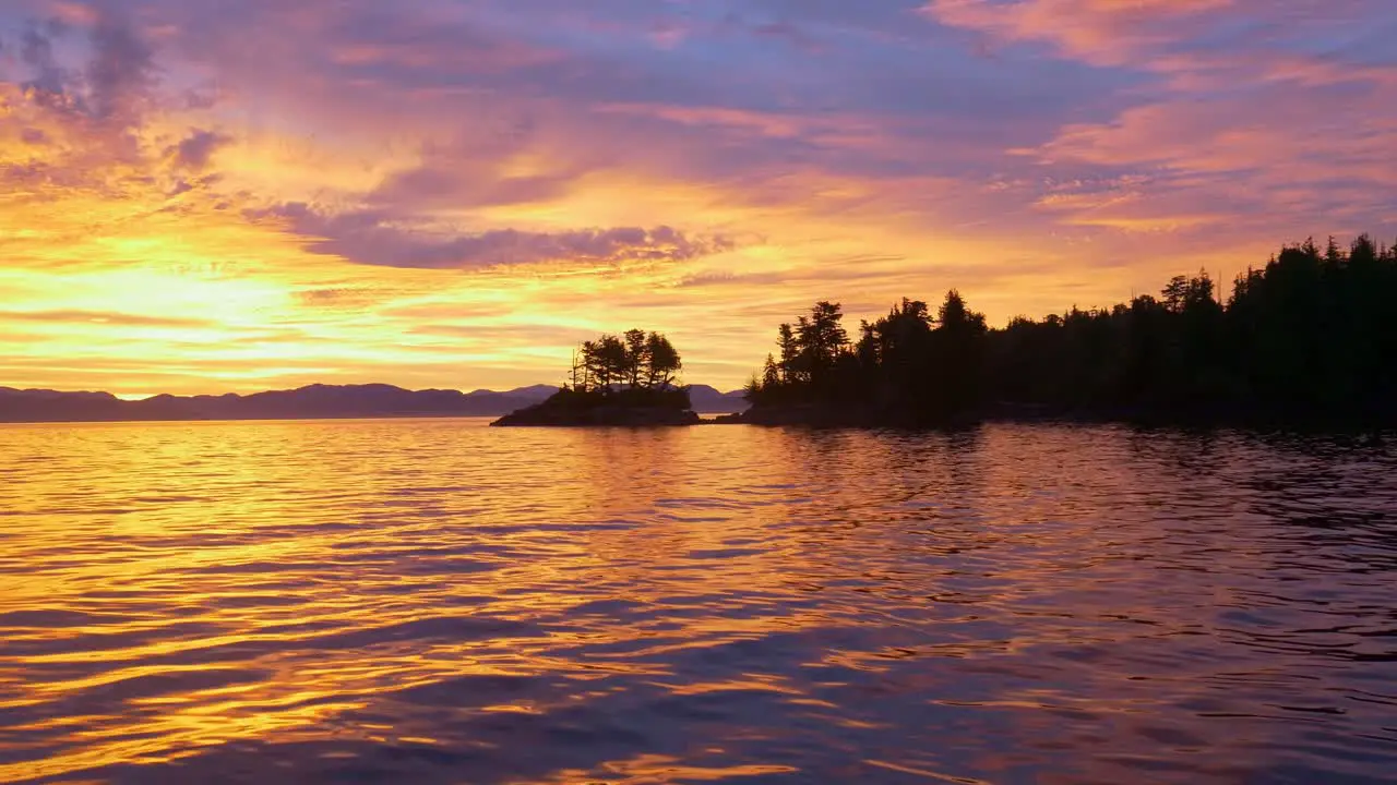 Panning over water during ocean sunrise in remote and empty bay