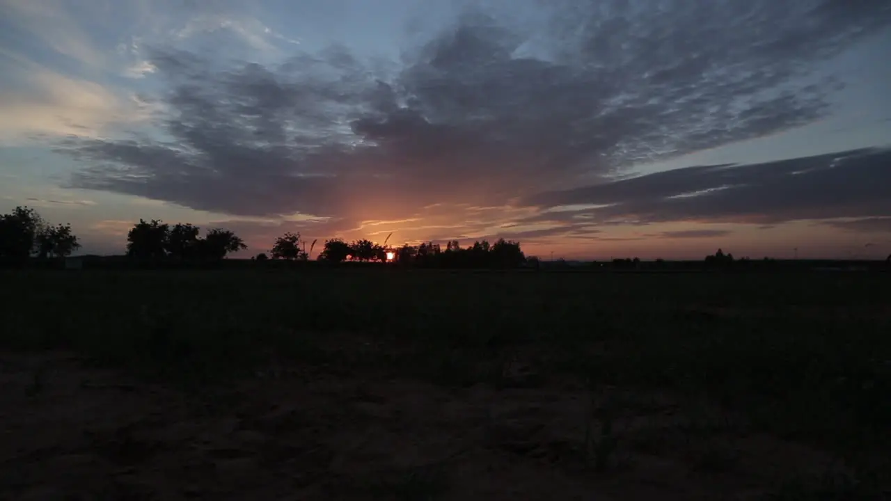 Cowboy riding a horse at sunset in the countryside static view of the colorful sky and the rider in silhouette