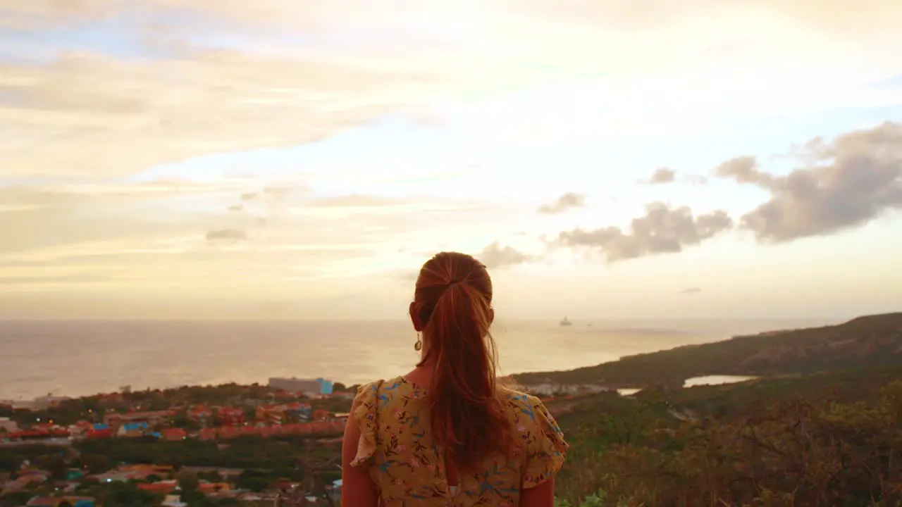 Young girl looking at a sunrise in a beautiful yellow dress