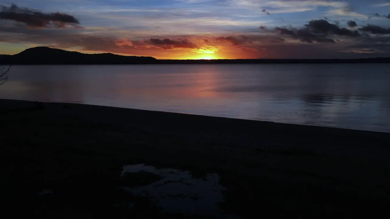 Dusk Dawn over hills shot from the edge of a large lake drone slide to tree branches Pt2- Ocean and sea stock videos