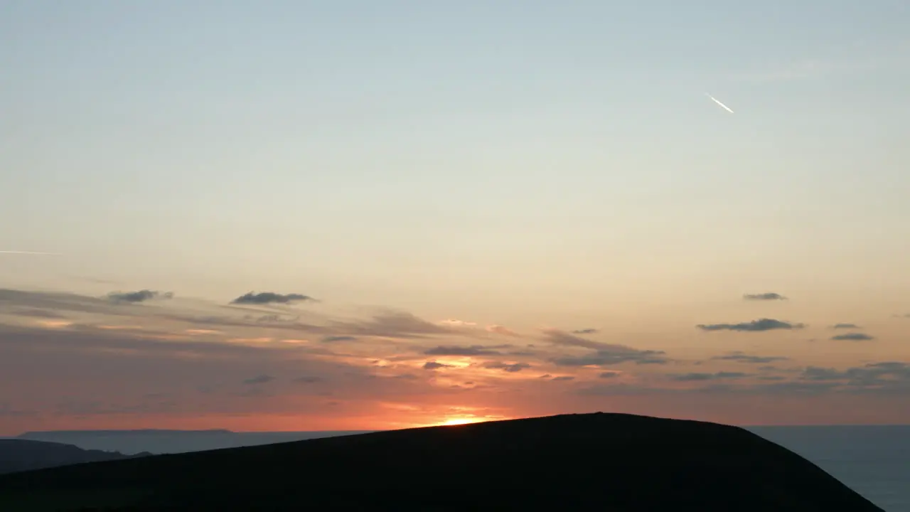 Beautiful Sunset Behind Coastal Mountain Top with Dramatic Clouds 4K