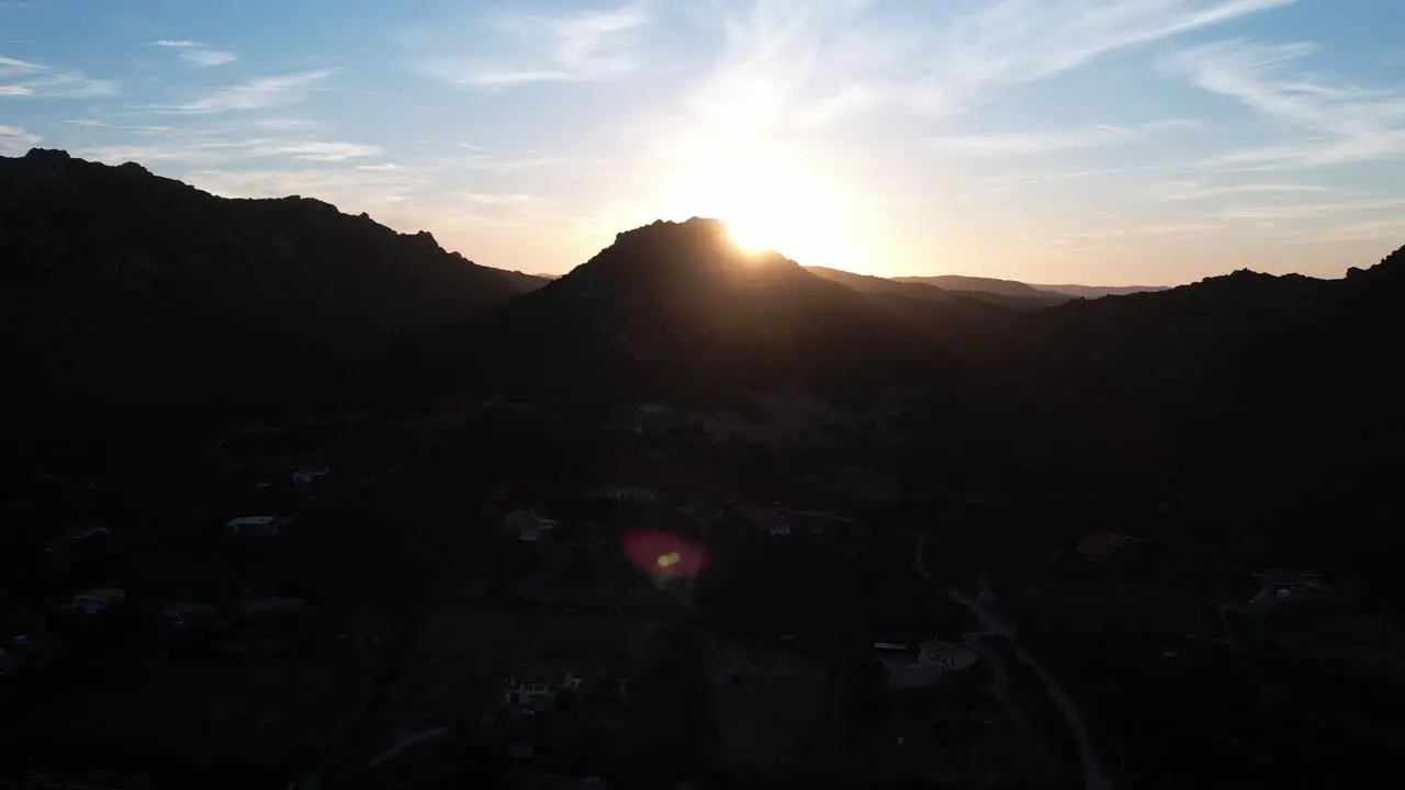 Dramatic Golden Yellow Sunset Over Silhouetted Sardinian Hilltop Landscape Creating Lens Flares