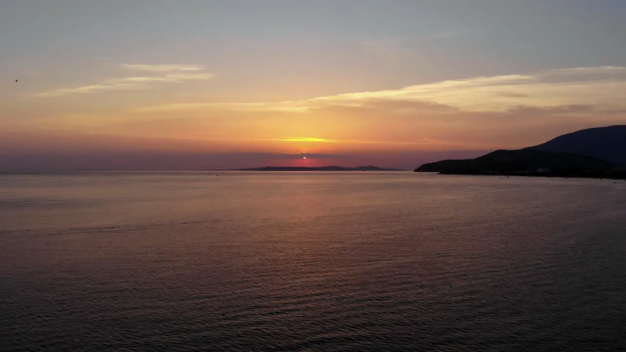 Aerial backward flight over Marmara sea at sunset when the sun behind the clouds Turkey