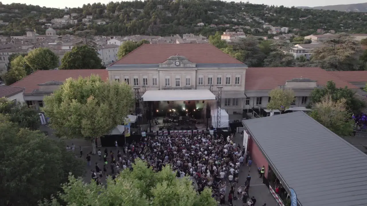 Drone captures rock concert stage with flashing lights and energetic audience