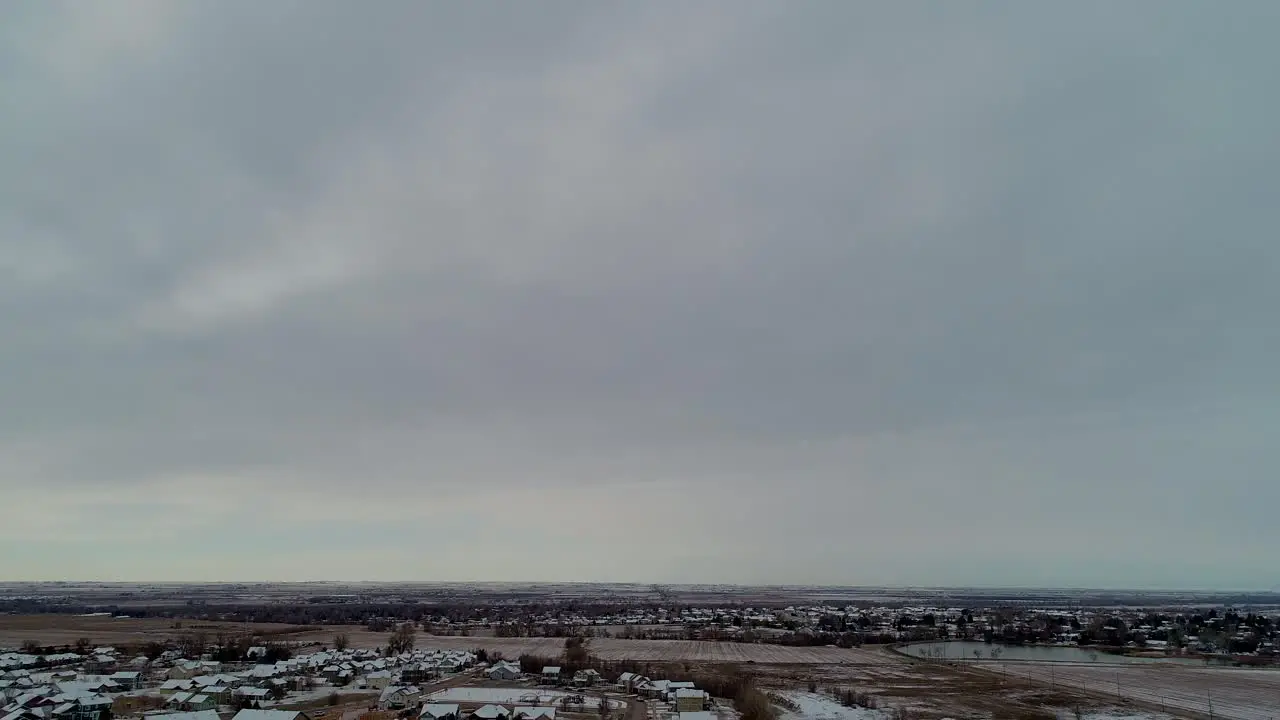 A gimbal down to reveal snow covered roofs in this 4k drone shot of a small suburban neighborhood