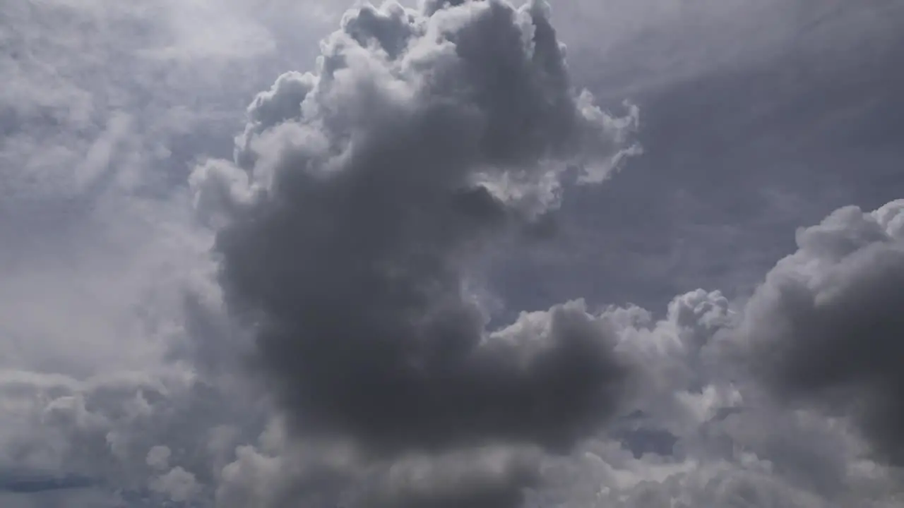 Time lapse of fast moving swirling afternoon storm clouds against a backlit blue sky