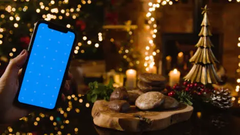 Christmas At Home With Traditional German Christmas Lebkuchen And Person With Blue Screen Mobile Phone