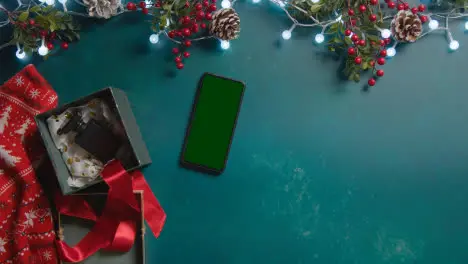 Overhead Shot Of Person With Green Screen Mobile Phone With Christmas Decorations And Gifts 2