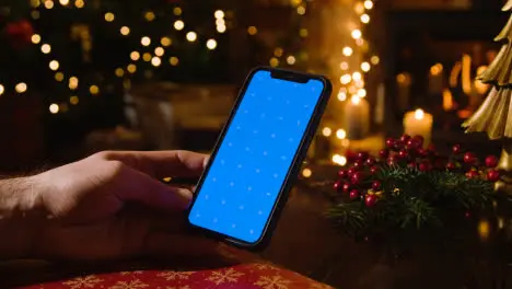 Christmas At Home With Person Using Blue Screen Mobile Phone