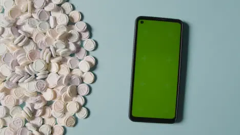 Pile Of Heart Candy With Romantic Messages Of Love Next To Person Using Green Screen Mobile Phone