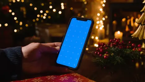 Christmas At Home With Person Using Blue Screen Mobile Phone 1