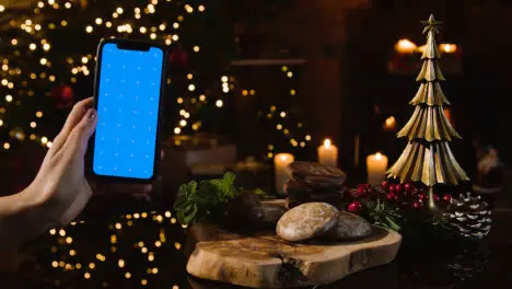 Christmas At Home With Person Eating Traditional German Christmas Lebkuchen And Person Holding Blue Screen Mobile Phone