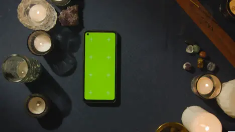 Overhead Shot Of Person Giving Tarot Card Reading With Green Screen Mobile Phone On Table