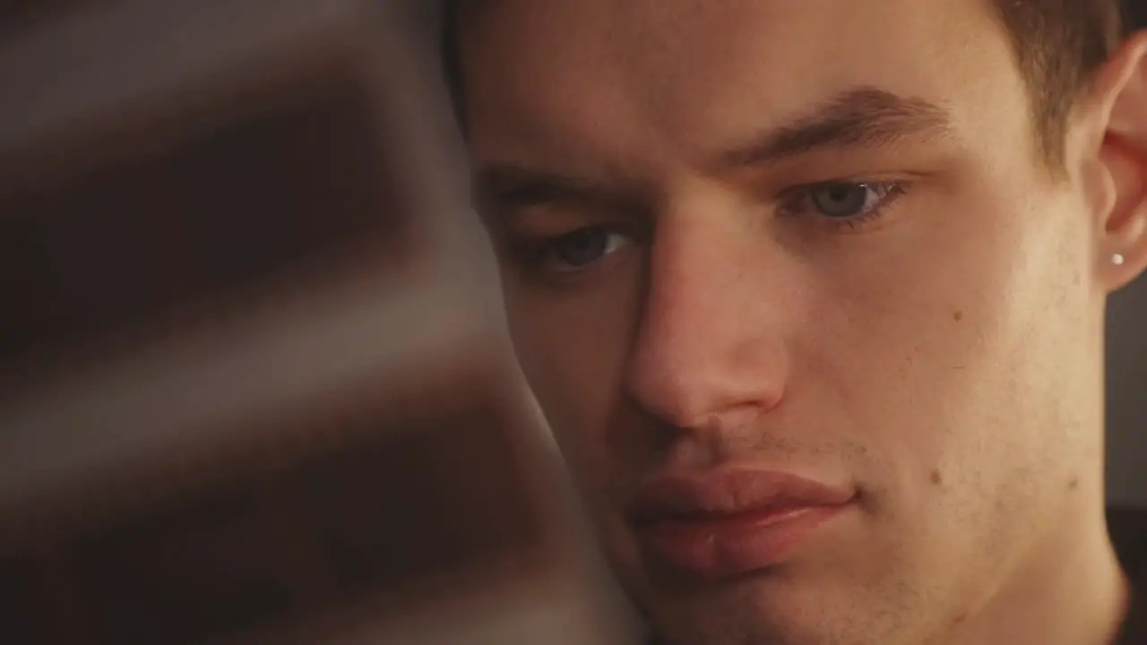 Face Of A Man Looking At Film Negatives In Blurred Foreground