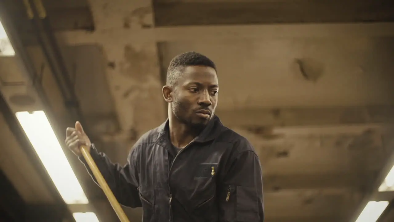 Janitor dancer pushes mop and looks sorrowful low angle medium closeup