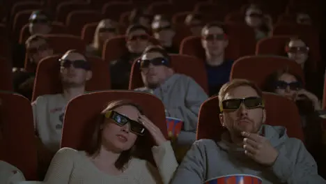 Spectators in 3D glasses strained watching scary flm Audience in 3d cinema