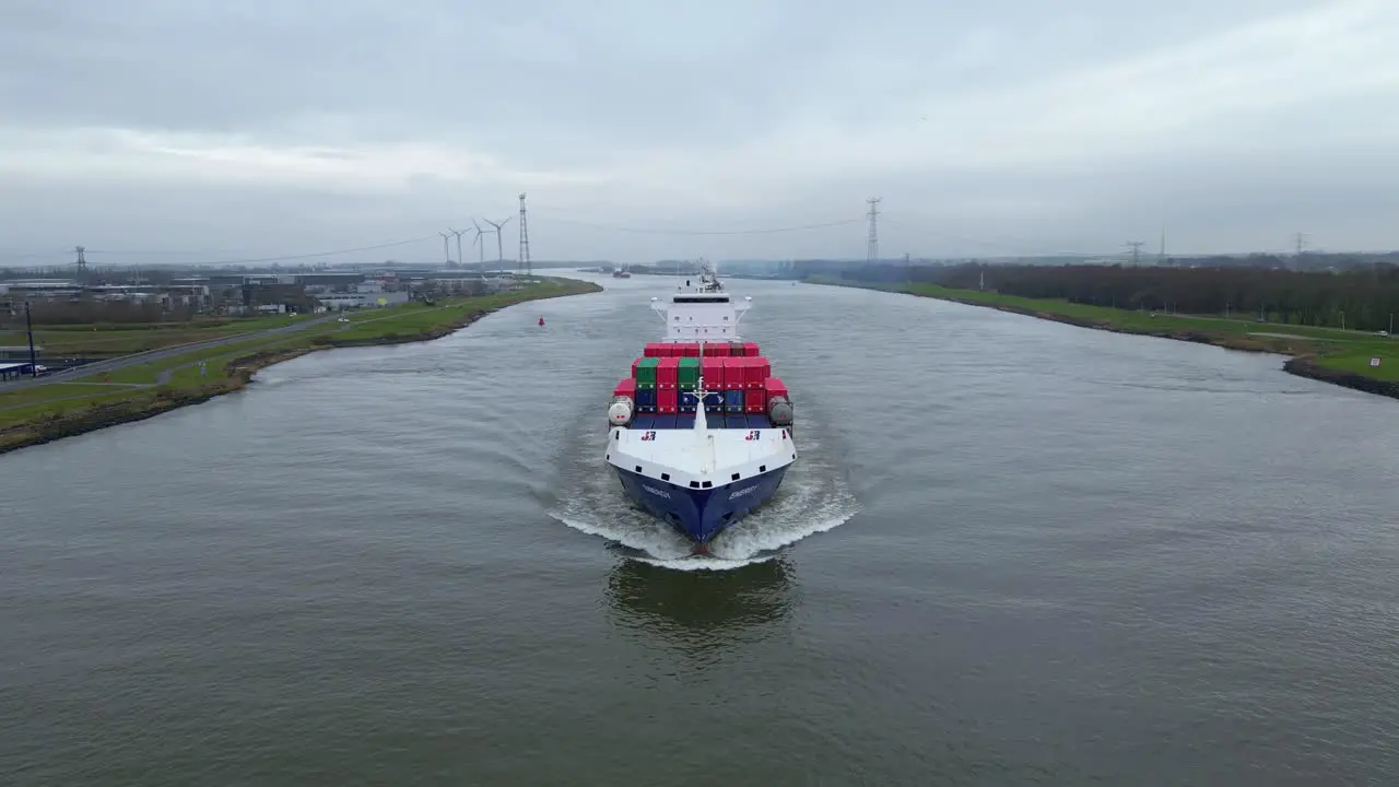 Aerial Tracking Shot Off Forward Bow Of Energy Cargo Ship Carrying Viasea Intermodal Containers Navigating Along Oude Maas