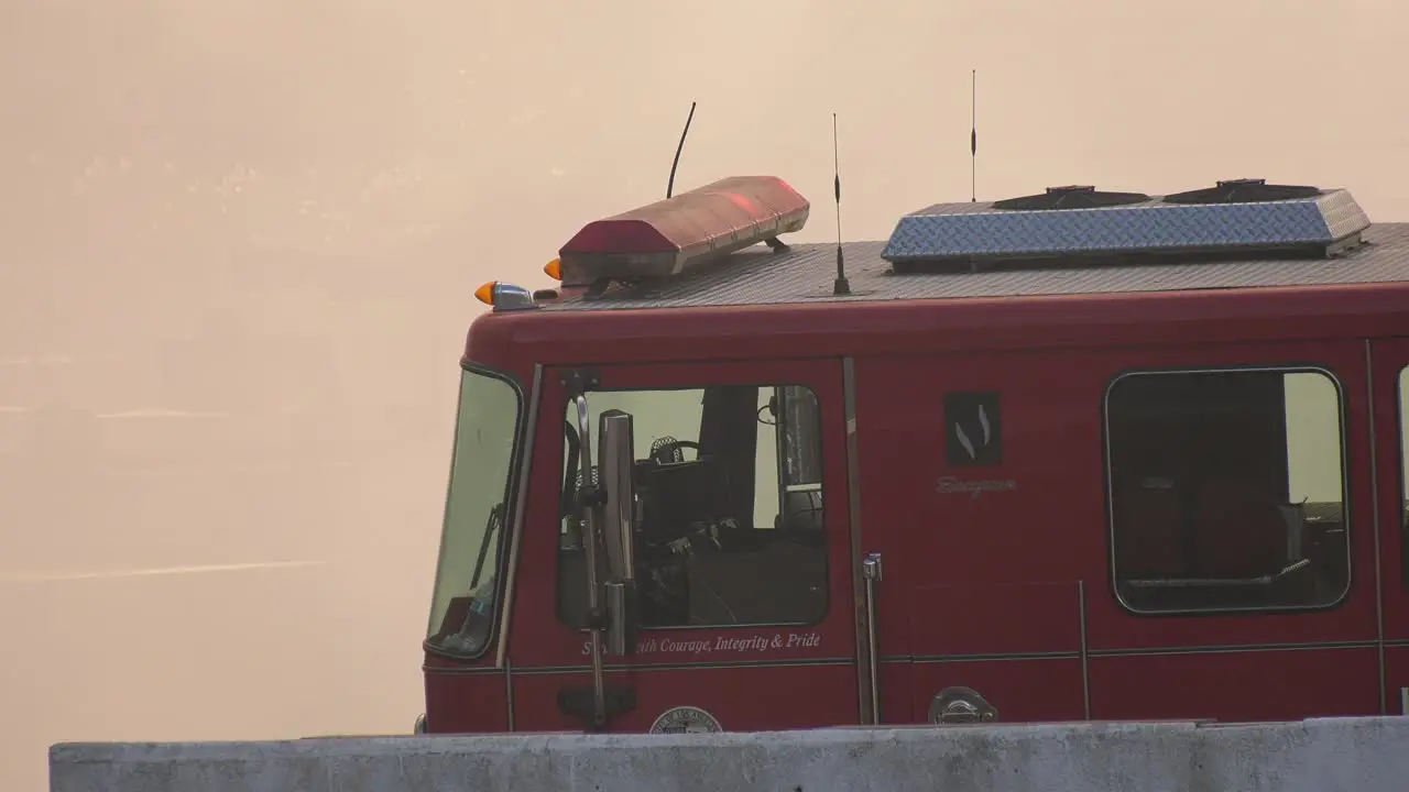 Fire truck illuminated with large smoke cloud