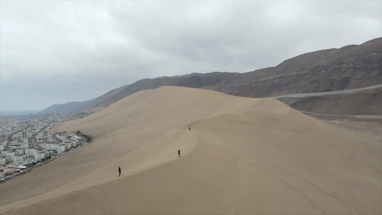 Tourist hiking the Cerra Dragon dune in Iquique Tarapaca Chile in a cloudy afternoon