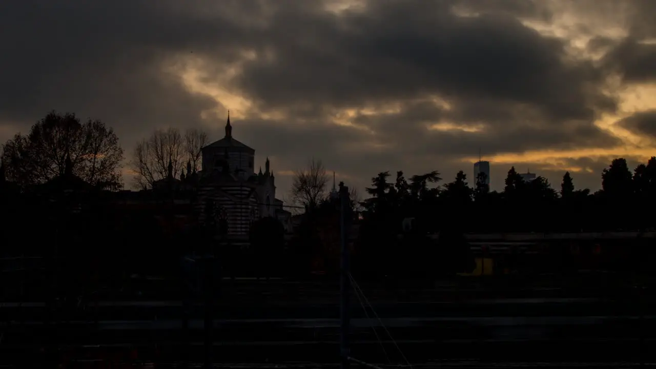 Timelapse on railway and Monumental Cemetery in Milan with clouds and sunset