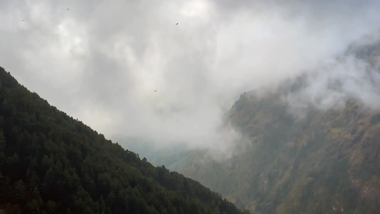 Two mountains forming a huge valley with a time-lapse of clouds flowing into the valley of the Himalaya Mountains