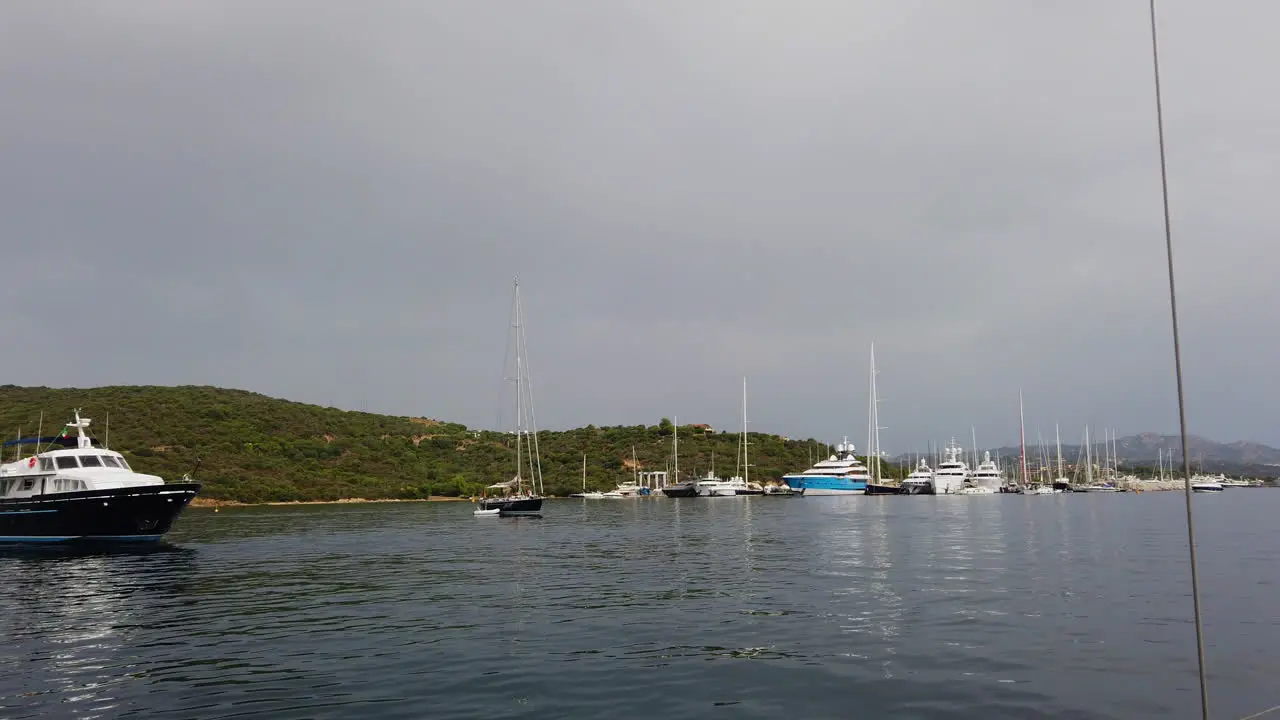 POV from moving boat to yachts at anchor