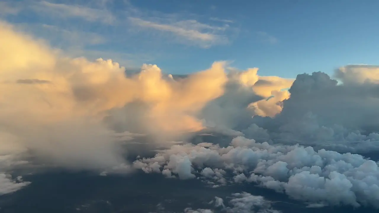 Aerial view of some huge cumulonimbus in the afternoon iluminated with awesome colors