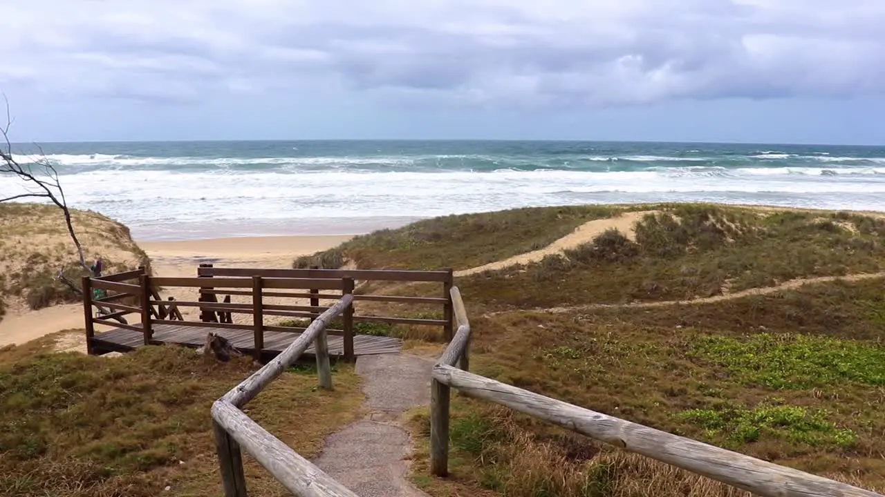 Wooden walkway entrance to tropical beach on a cloudy day in Sunshine coast Australia