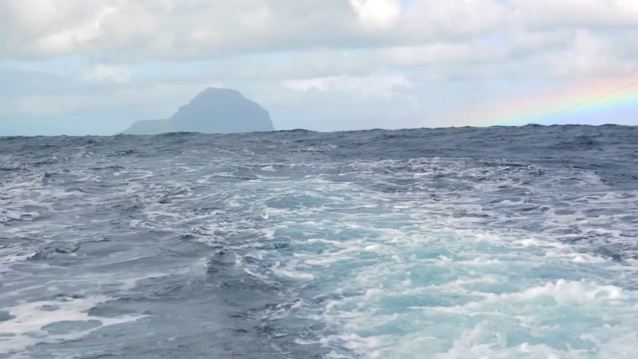 Wavy ocean and distant island view from the ship