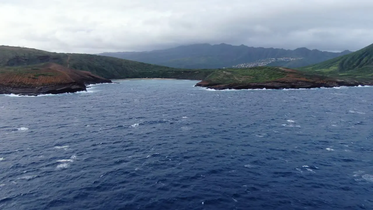 drone pans along hanauma bay ocean side on a gloomy day