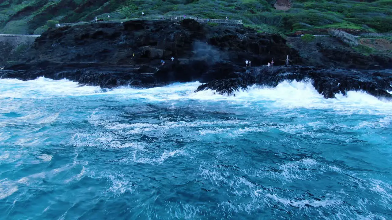 Halona Blowhole on a rough day as tourists stand close and watch