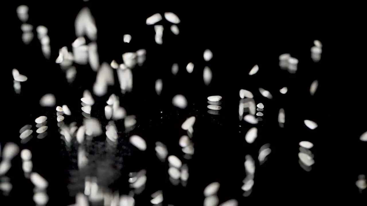 Rice falls in slow motion on a mirror surface