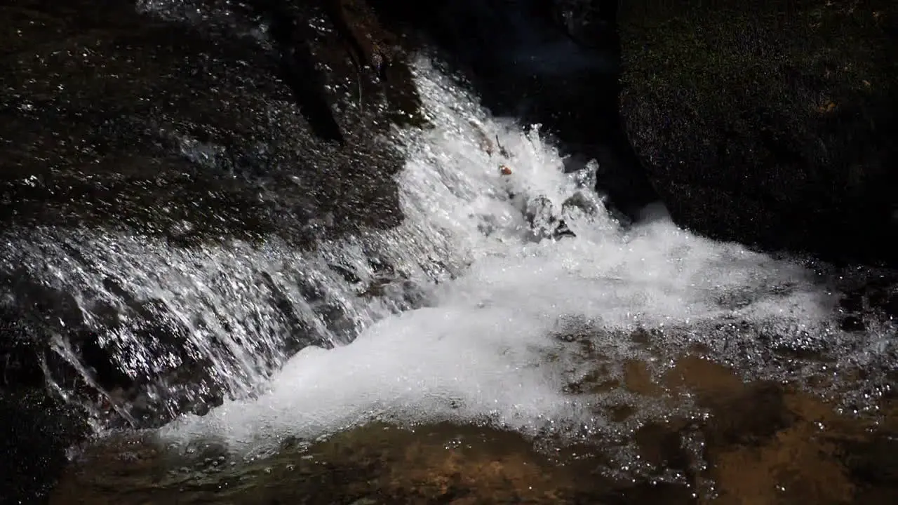 Small waterfall in mountain stream shot slow motion at 180 frames per second