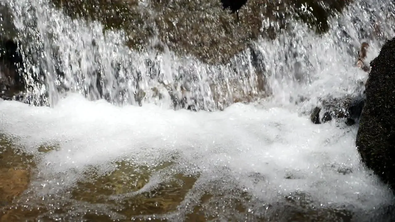 Impressive slow motion shot of water cascading in mountain stream shot at 180 frames per second