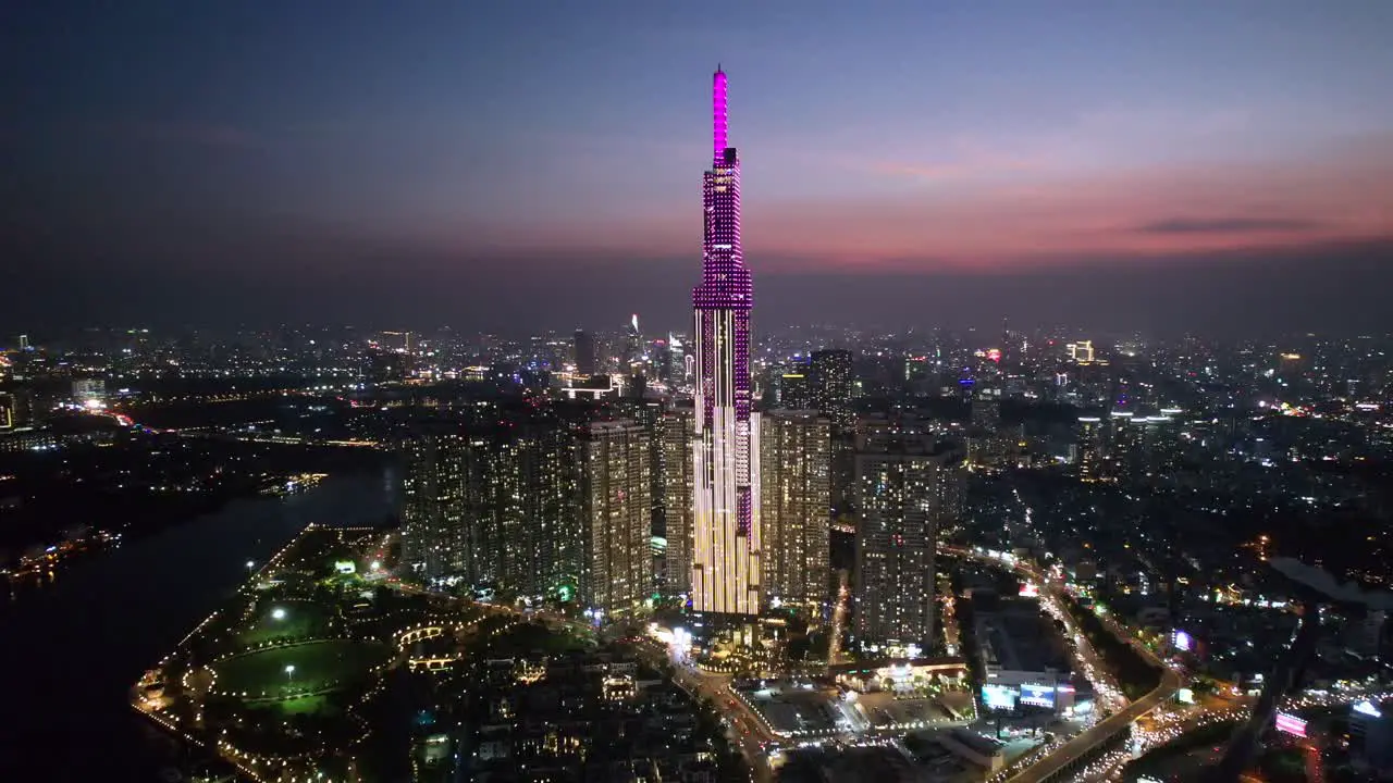 wide aerial zoom in of the Saigon skyline with Landmark 81 building lit up in a modern asian city