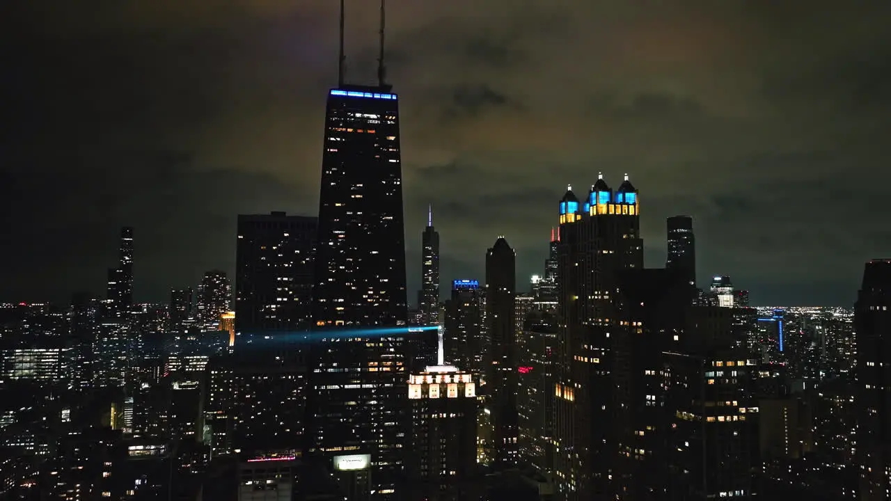 Static drone shot of the night lit Streeterville skyline of cloudy Chicago USA