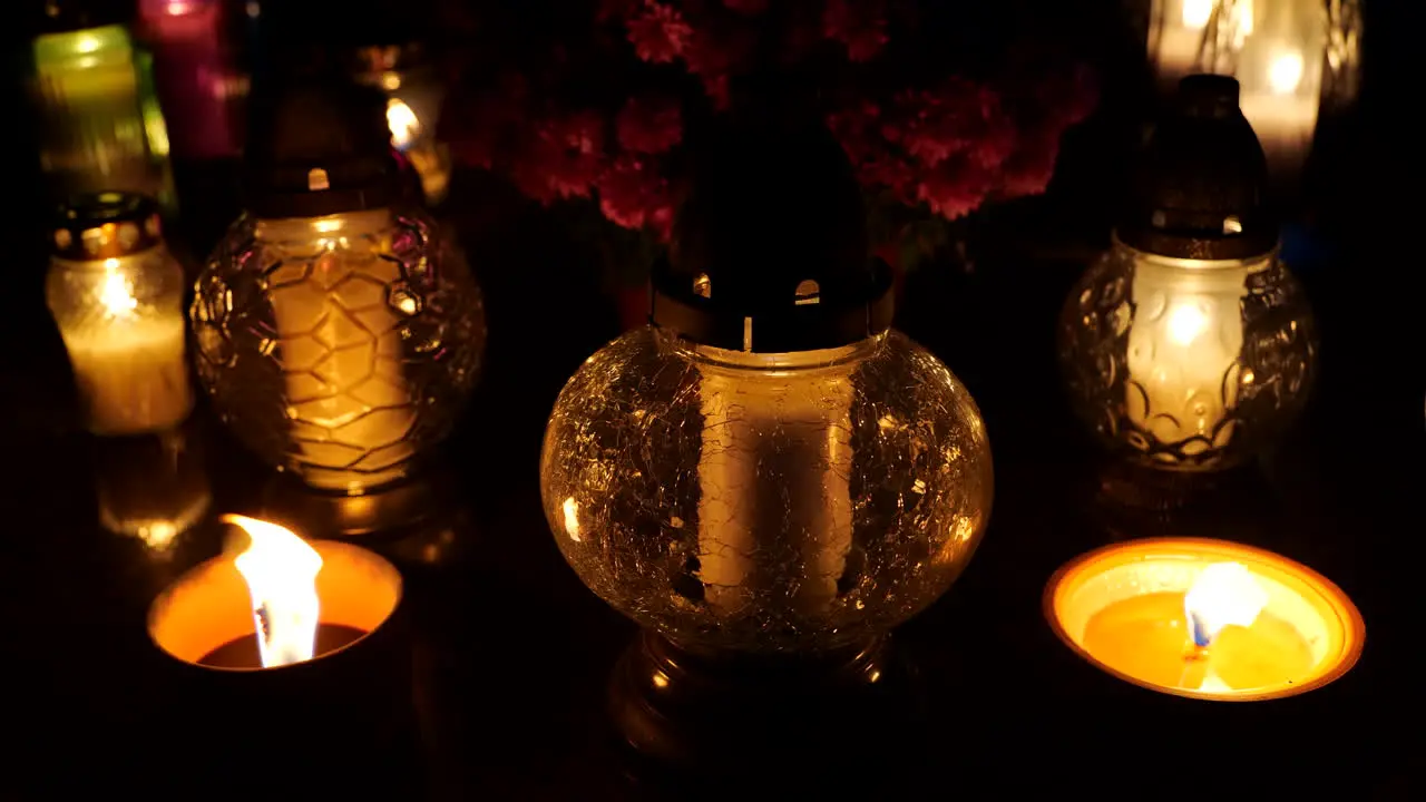 Grave candle lights burning at night on cemetery tomb