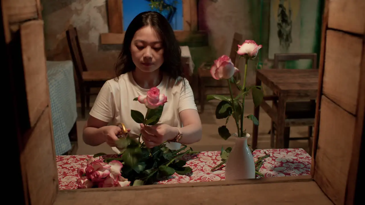 woman trims roses she received from her husband as a valentines Day gift from her husband