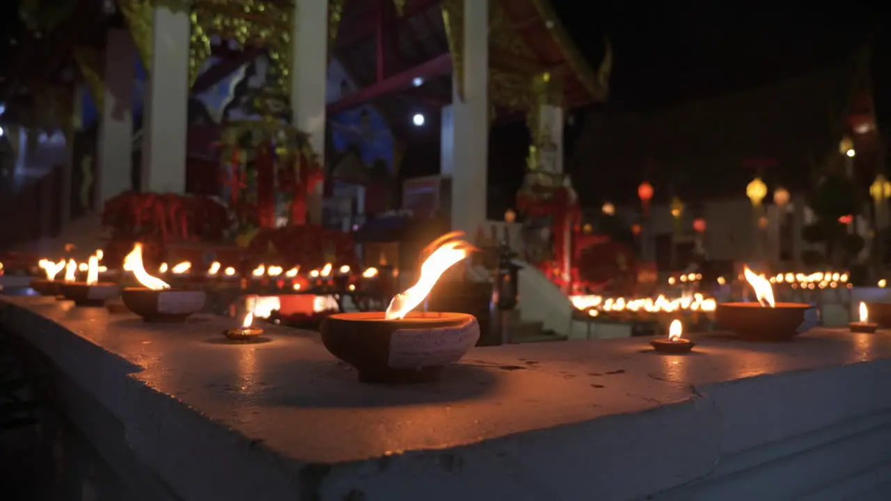 Countless traditional and holy candles burning infront of buddhist temple at night time during Loy Krathong Festival in Chiang Mai Thailand