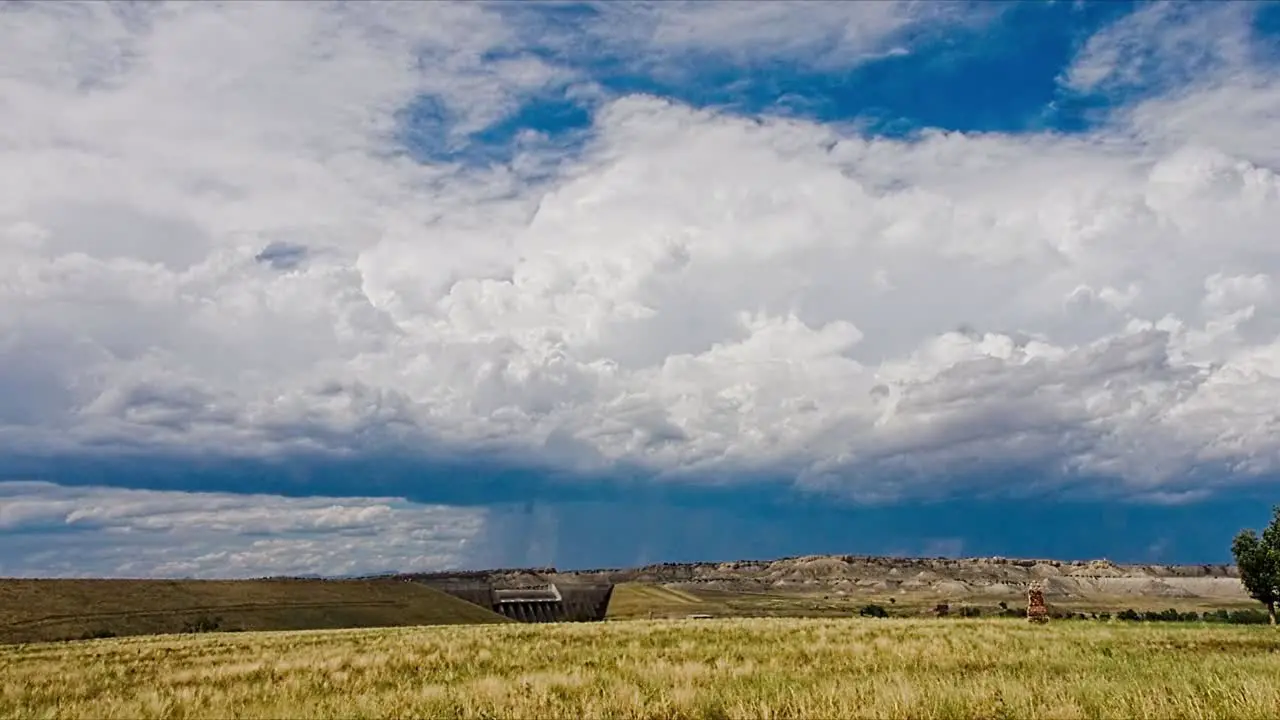 A mid-summer storm passes over Pikes Peak with the Lake Pueblo dam in the foreground