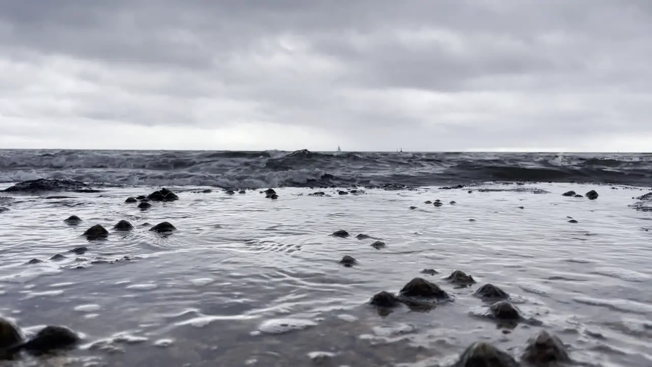 Low seascape showing the waves flowing over the rocks with barnacles on a grey cloudy day