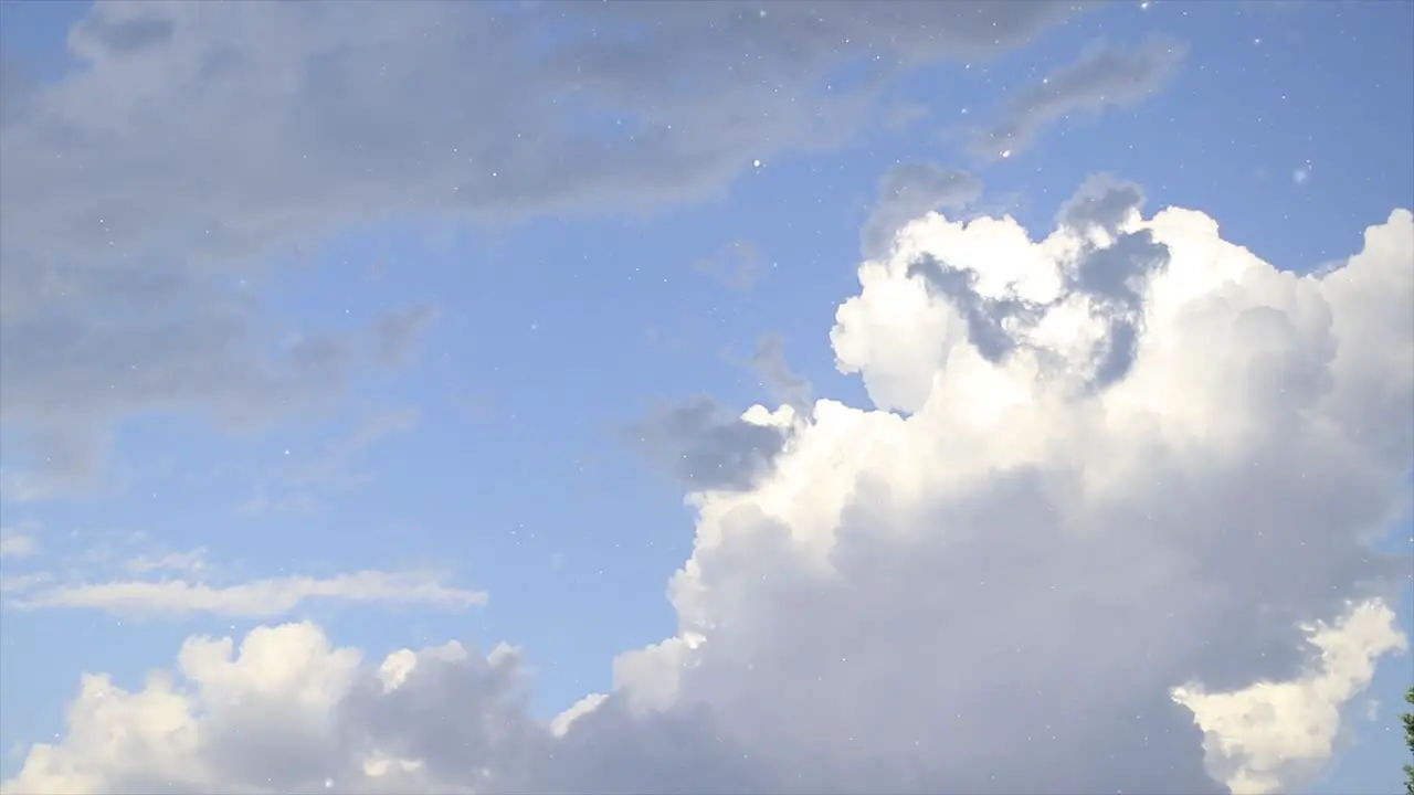 Shiny raindrops falling from the sky filled with dark and white clouds