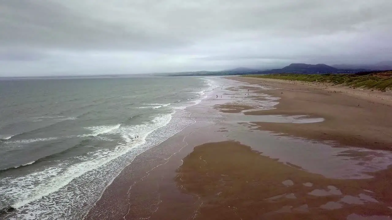 Ariel view of Harlech beach Wales with vast sands crashing waves and a stormy sky