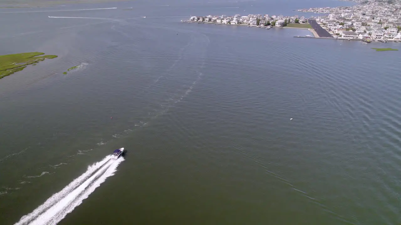 Amazing long tracking shot from Drone following a boat speeding up with two jetskis following in wake